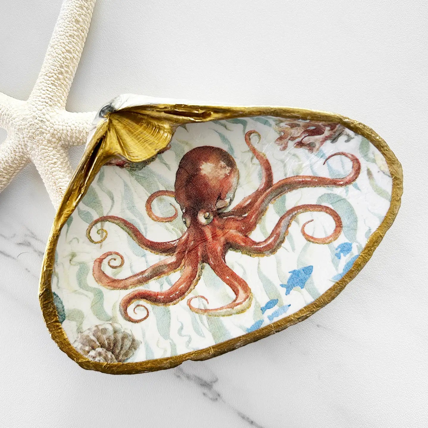 Decorative shell with an octopus design on a marble surface